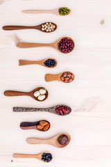 Assortment of beans and lentils in wooden spoon set up on wooden