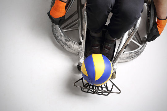 Siatk&oacute;wka.Mężczyzna na sportowym w&oacute;zku  inwalidzkim z piłką 
