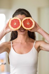 Young woman holding slices of blood orange