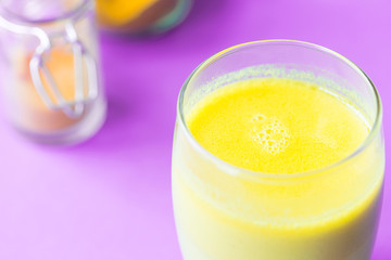 Turmeric with Coconut Milk Drinks and Ghee on Purple Background Good for Beauty and Health, Gives a lot of Energy, Close-up