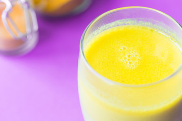 Turmeric with Coconut Milk Drinks and Ghee on Purple Background Good for Beauty and Health, Gives a lot of Energy, Close-up