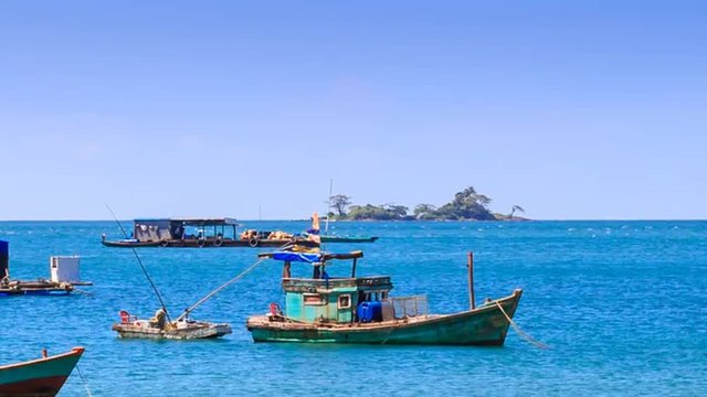 Vietnamese Fishing Boats Rock in Bay against Island on Horizon