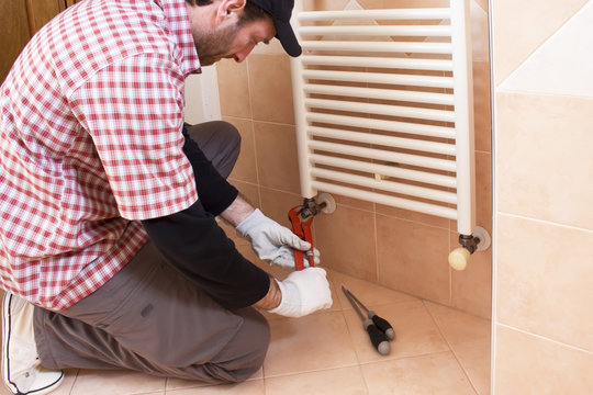 Plumber performs a repair of a radiator