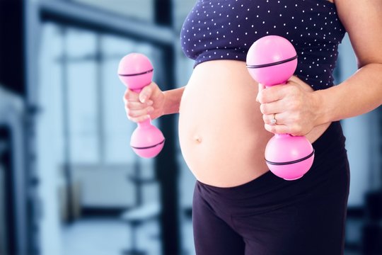 Composite image of midsection of pregnant woman lifting dumbbells