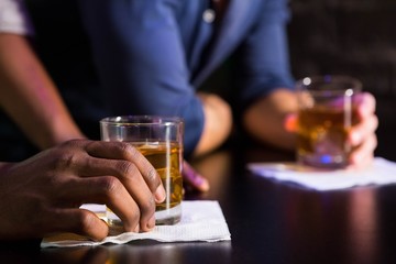 Two men having whiskey at bar counter