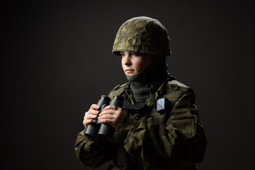 Portrait of unarmed woman with camouflage. Young female soldier observe with binoculars. War, military, army people concept