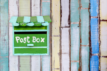 Green wooden mailbox with wooden background