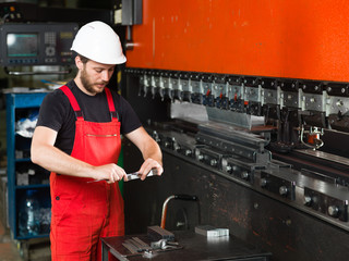 worker measuring a piece of meta