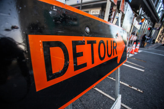 Big orange sign Detour in the middle of the street