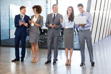 Businesspeople using mobile phone, lap top and digital tablet