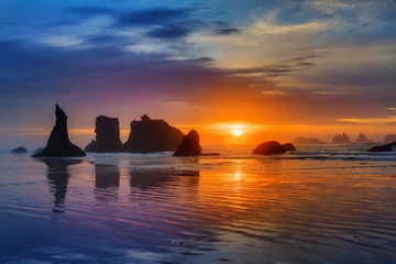 Papier Peint photo Eau Sunset at Bandon Beach over the Pacific ocean with reflections on wet sand, Bandon, Oregon