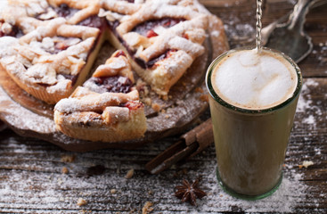 Delicious cake with cherries, icing sugar and a cup of coffee