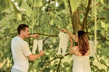 Obraz premium pregnant couple holding children's pajamas outdoor