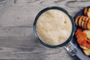 Beer in a glass on wooden background. Beer and beer snack.
