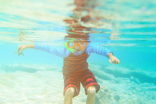 little boy swimming and snorking in ocean