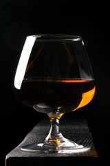 Glass of cognac on the black table
