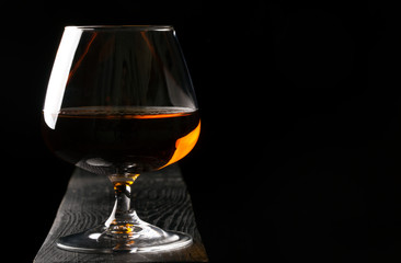 Glass of cognac on the black table