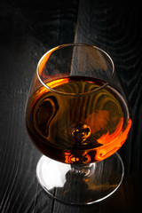 Glass of cognac on the black table