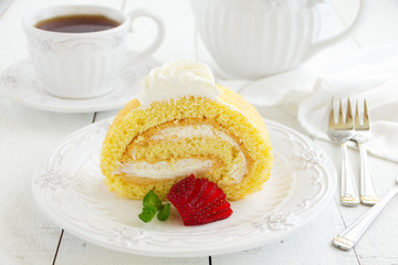 Biscuit roll with strawberry jam, and strawberries.