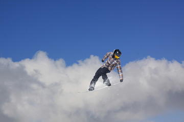 Flying snowboarder on mountains. Extreme sport.