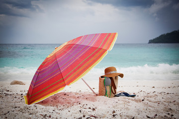 Straw hat and bag on a tropical beach