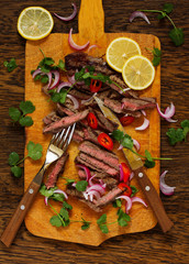 Roasted beef steak with onions and herbs.