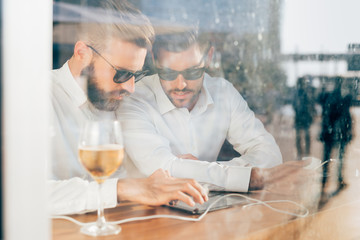 Two young bearded caucasian modern business man sitting in a bar