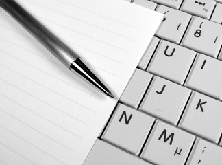 Pen, paper and white laptop. Business concepts.