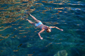 Young woman snorkeling in tropical lagoon