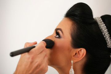 Gorgeous bride getting professional makeup on wedding day