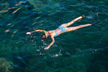 Fototapeta na wymiar Young woman snorkeling in tropical lagoon