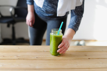 Green monster cocktail in hand at the young woman.