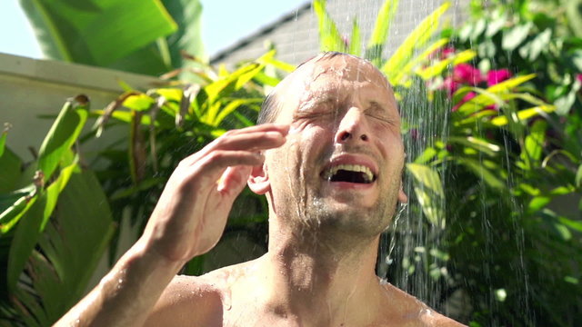 Young, happy man taking shower super slow motion 240fps
