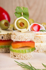 finger foods with bread, peppers, cucumber, cheese and olives