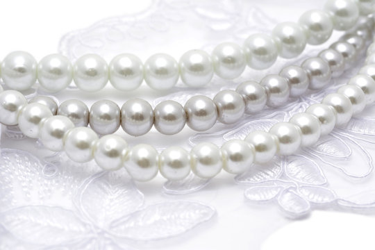 Pearl beads strings on white lace