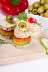 finger foods with bread, peppers, cucumber, cheese and olives