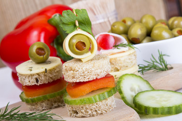 finger food with bread, peppers, cucumber, cheese and olives