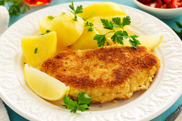 Baked chicken breast with a crispy crust, served with boiled potatoes.
