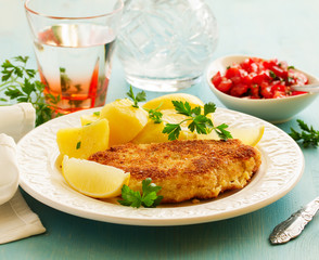 Baked chicken breast with a crispy crust, served with boiled potatoes.