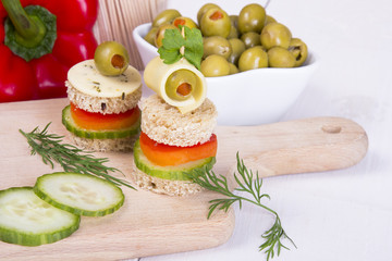 finger foods with bread, peppers, cucumber, cheese and olives