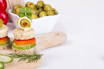 finger food with bread, peppers, cucumber, cheese and olives