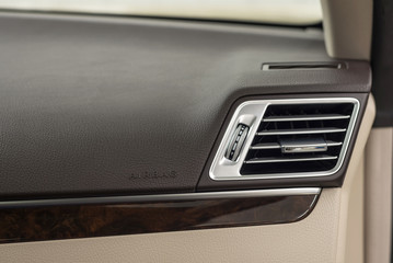 Car dashboard. Airbag panel and air conditioning hole. Interior detail.