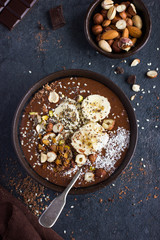 chocolate and banana smoothie  topped with nuts and seeds