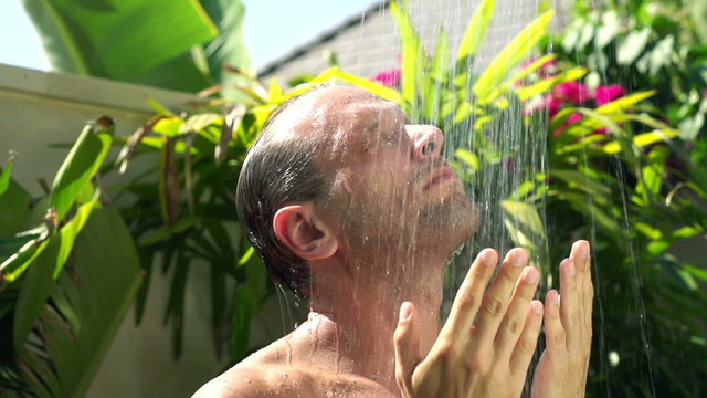 Young man washing his face under shower super slow motion 240fps
