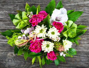 wedding bouquet with roses and white gerberas on an old wooden t