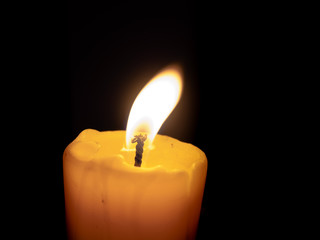 Close-Up Of Illuminated Candle In Black Background