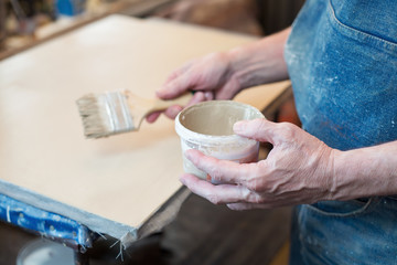 An artist priming canvas. Selective focus
