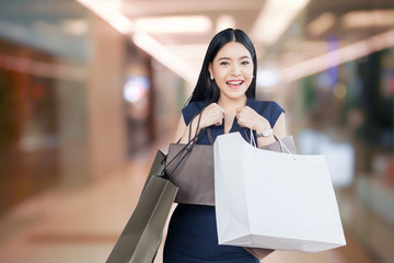 Beautiful young woman with shopping bags isolated on department