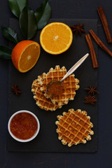 Homemade waffles with orange jam and milk.