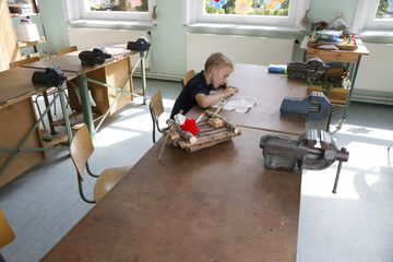 Little boy is working for a boat. 